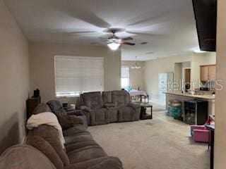 carpeted living room with ceiling fan