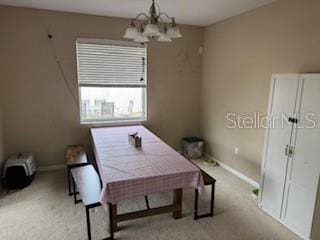 carpeted dining room with an inviting chandelier