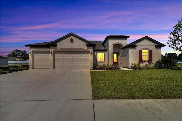 view of front of property with a garage and a yard