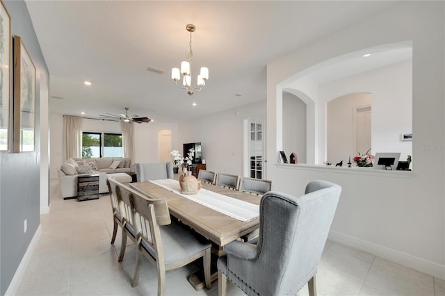 tiled dining space with ceiling fan with notable chandelier