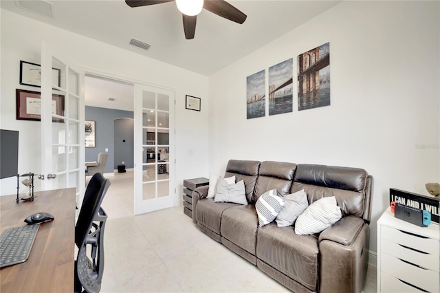 tiled living room featuring ceiling fan and french doors