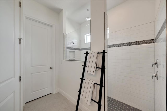 bathroom with a tile shower and tile flooring