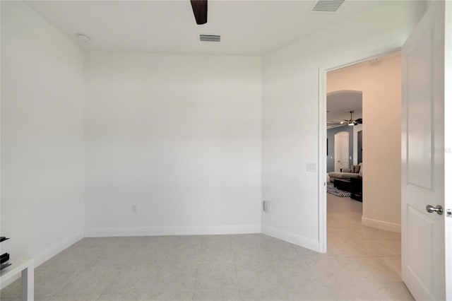 tiled empty room featuring ceiling fan