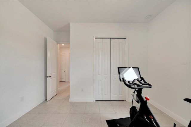 workout room featuring light tile flooring