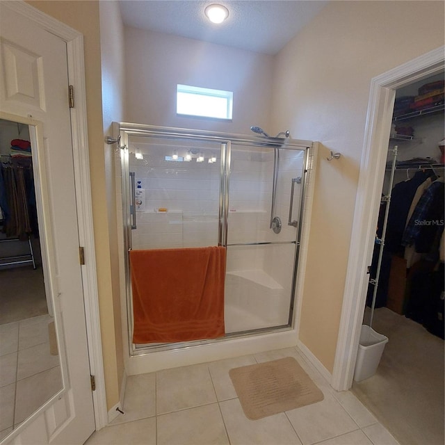 bathroom featuring tile patterned flooring and a shower with shower door