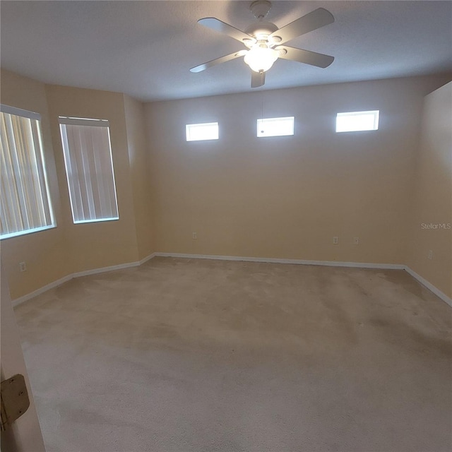 carpeted spare room with a healthy amount of sunlight and ceiling fan