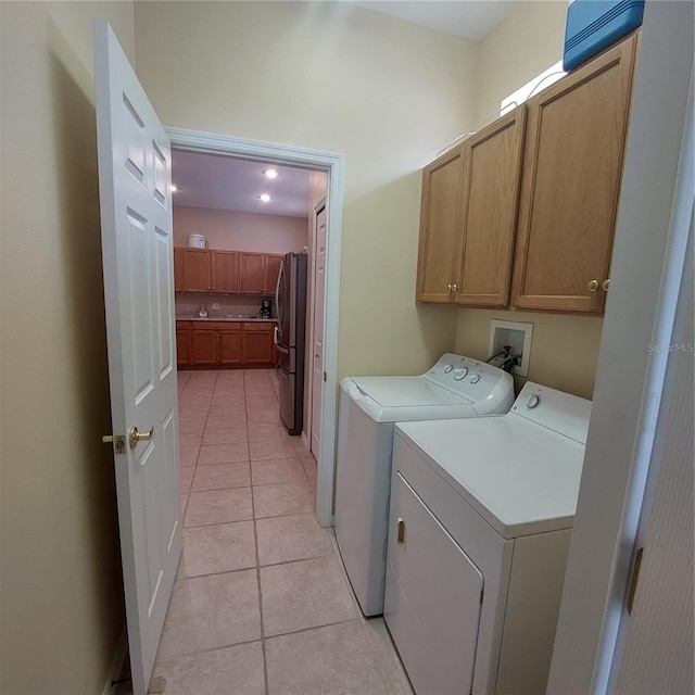 washroom with cabinets, light tile patterned floors, and separate washer and dryer