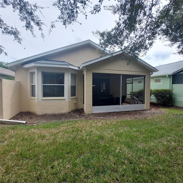 back of house with a sunroom and a yard