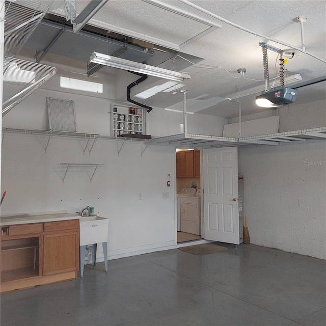 garage with a garage door opener, sink, and washer and dryer