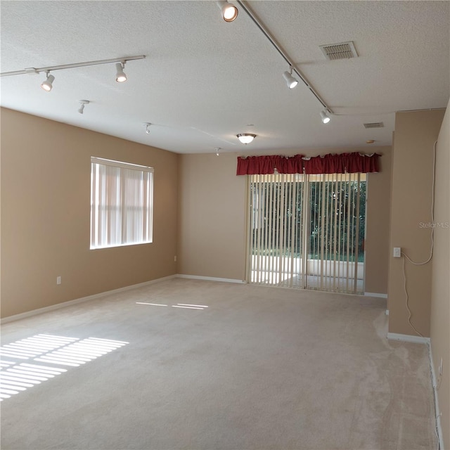 carpeted spare room with a textured ceiling