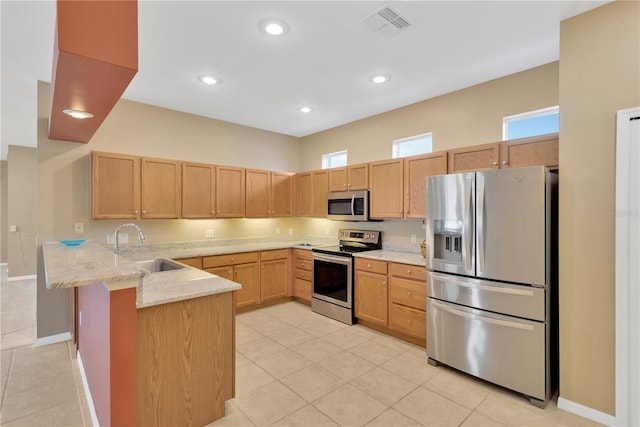 8049 Sanguinelli Rd, Land O Lakes, FL 34637 - kitchen with stainless steel appliances, a peninsula, a sink, light tile patterned floors, and light brown cabinetry