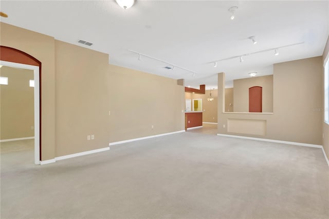 8049 Sanguinelli Rd, Land O Lakes, FL 34637 - unfurnished living room featuring baseboards, carpet, and track lighting