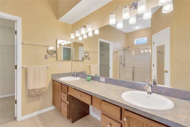 8049 Sanguinelli Rd, Land O Lakes, FL 34637 - full bathroom with a spacious closet, a shower stall, double vanity, tile patterned flooring, and baseboards