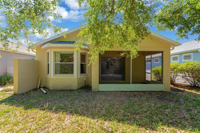 8049 Sanguinelli Rd, Land O Lakes, FL 34637 - rear view of house with stucco siding and a sunroom