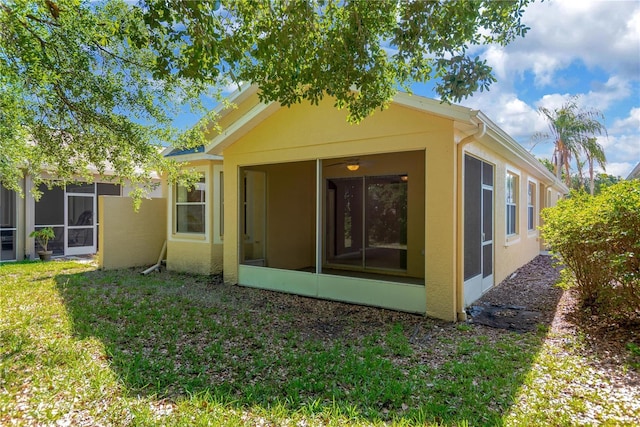 8049 Sanguinelli Rd, Land O Lakes, FL 34637 - rear view of house featuring a sunroom, stucco siding, and a yard