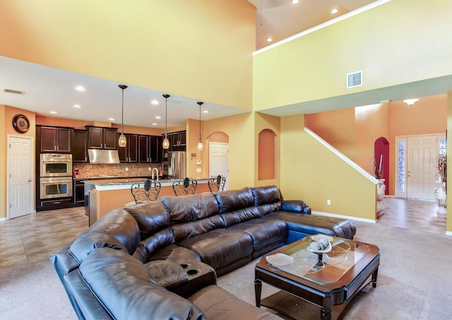 living room featuring light tile floors and a high ceiling