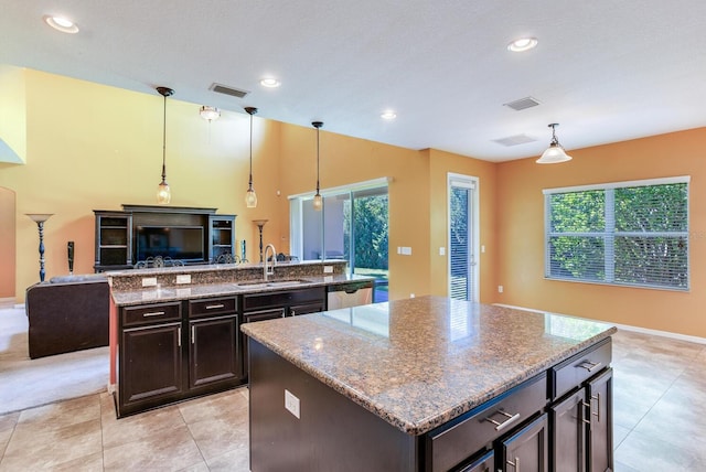 kitchen with a kitchen island, plenty of natural light, hanging light fixtures, and sink