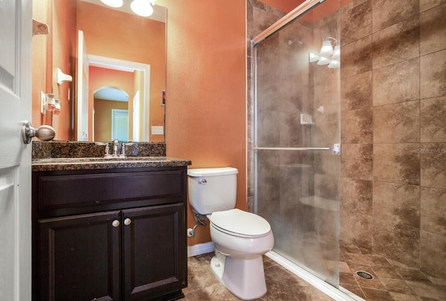 bathroom with an enclosed shower, vanity with extensive cabinet space, toilet, and tile flooring