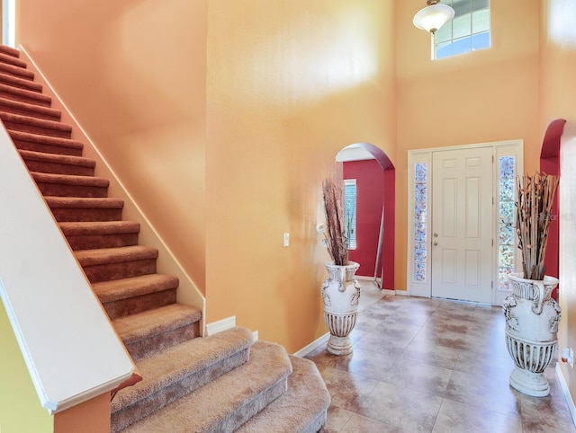 tiled entryway with a wealth of natural light and a high ceiling