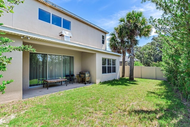 rear view of house featuring a patio and a yard