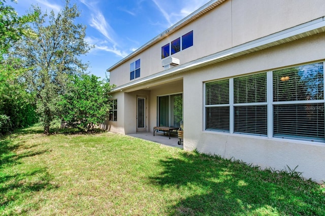 rear view of property with a patio and a lawn