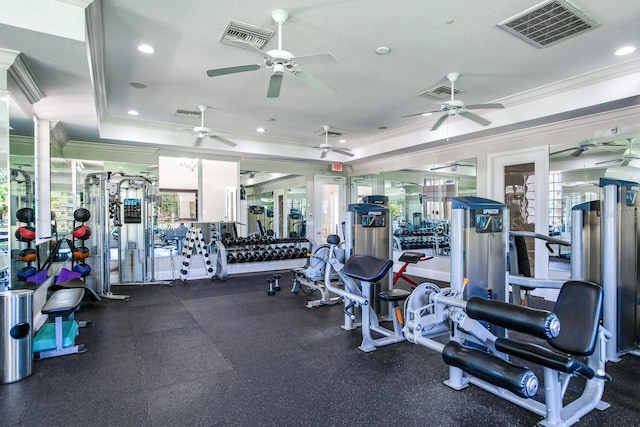 workout area with crown molding, ceiling fan, a textured ceiling, and a tray ceiling