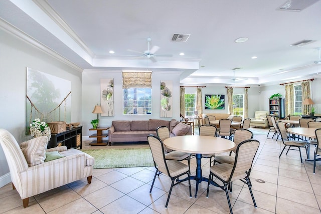 tiled dining room with ceiling fan, crown molding, and a tray ceiling