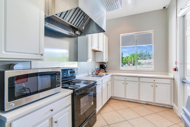 kitchen featuring light tile flooring, custom range hood, black range with electric stovetop, white cabinets, and sink