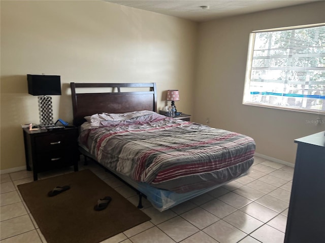 bedroom with light tile floors and multiple windows