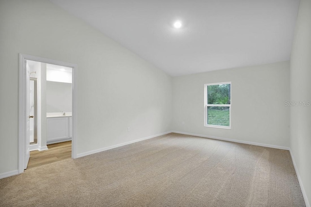 empty room with light carpet and lofted ceiling