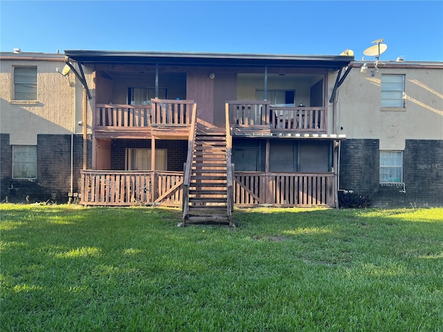 back of property with a lawn and a balcony