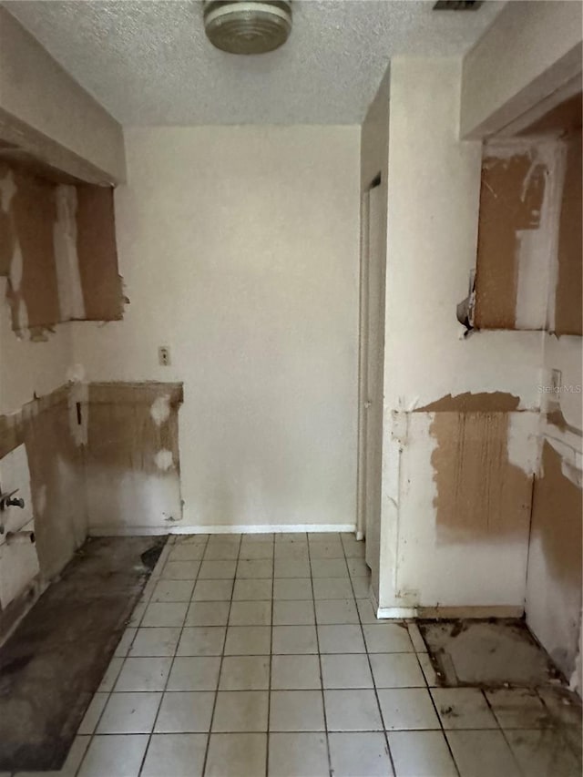 kitchen with a textured ceiling and light tile patterned floors