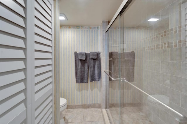 bathroom with a shower with shower door and toilet