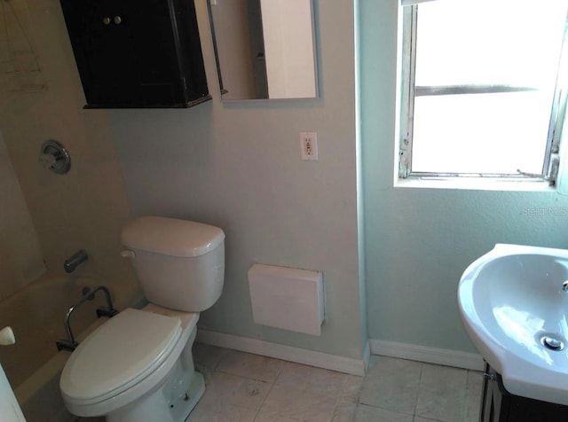 bathroom featuring toilet, sink, and tile flooring