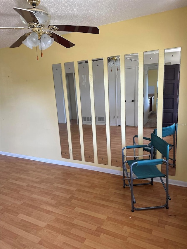 sitting room featuring a textured ceiling, ceiling fan, and light wood-type flooring