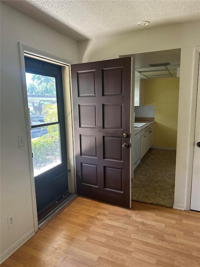 entryway featuring light hardwood / wood-style floors, a textured ceiling, and sink