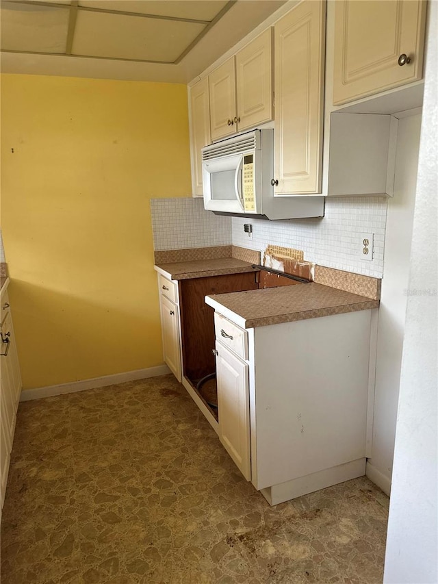 kitchen with dark tile flooring and backsplash