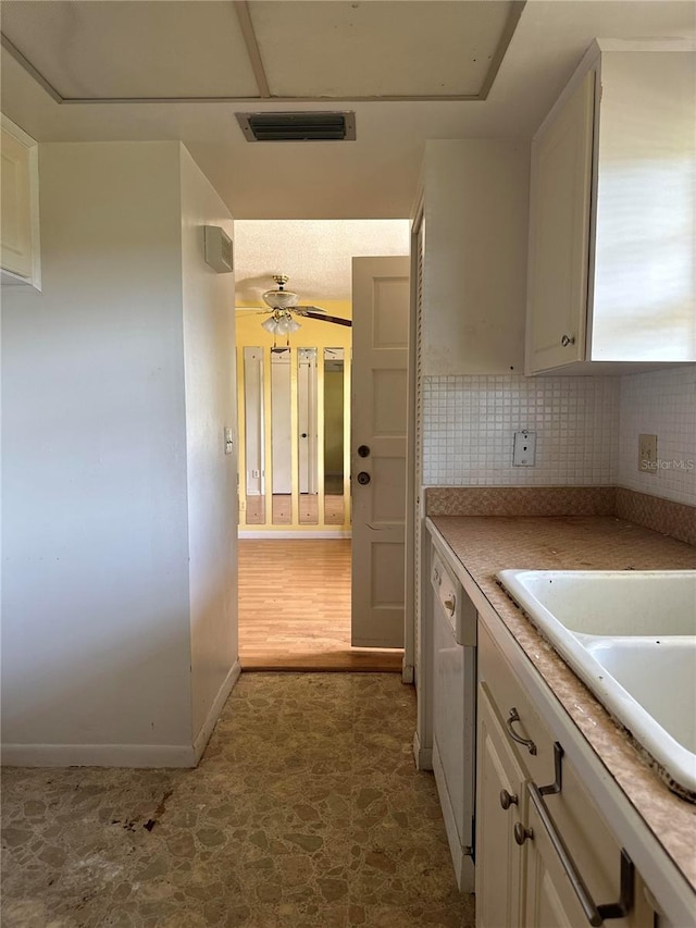 kitchen featuring dark tile floors, ceiling fan, white cabinets, white dishwasher, and tasteful backsplash