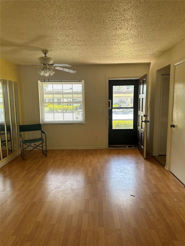 empty room featuring hardwood / wood-style floors, a textured ceiling, and ceiling fan