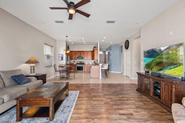 living room featuring ceiling fan and light wood-type flooring