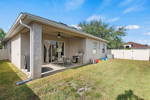 rear view of house featuring a lawn, central AC, ceiling fan, and a patio