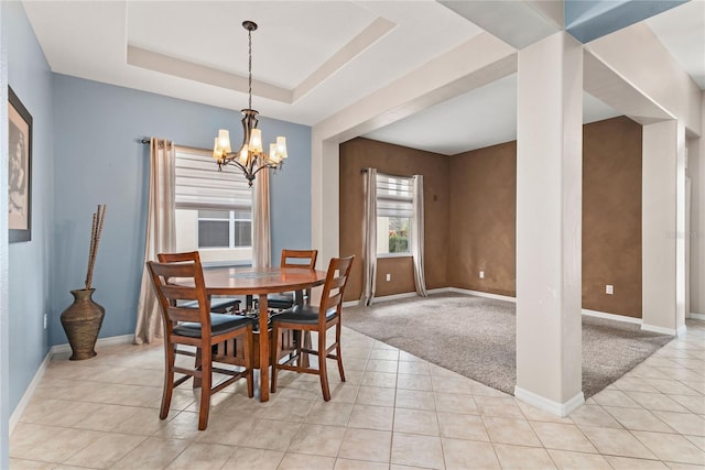 dining area with light colored carpet, a tray ceiling, and a chandelier