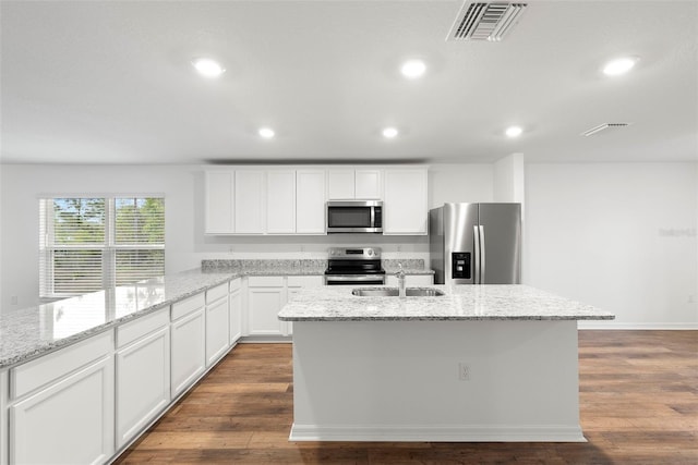 kitchen featuring white cabinets, sink, an island with sink, light stone counters, and stainless steel appliances