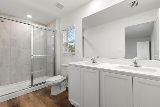 bathroom with vanity, hardwood / wood-style flooring, toilet, and an enclosed shower