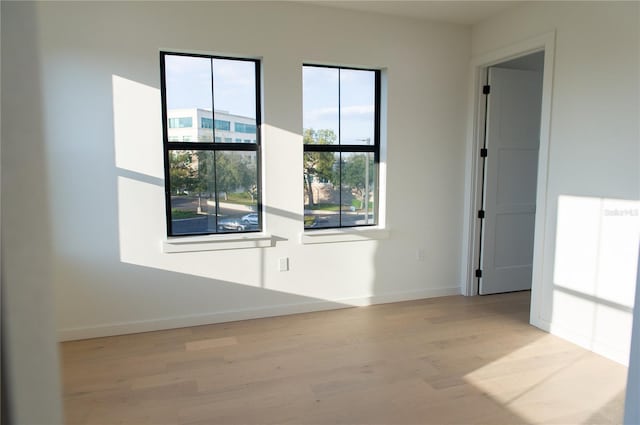 empty room featuring light wood-style floors and baseboards