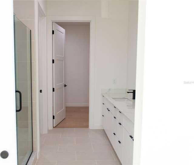 full bath with baseboards, a stall shower, and vanity