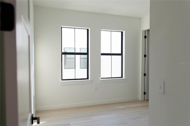 empty room featuring baseboards and light wood-type flooring