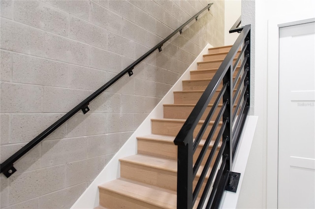stairs featuring concrete block wall