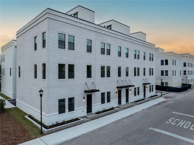 view of building exterior with uncovered parking
