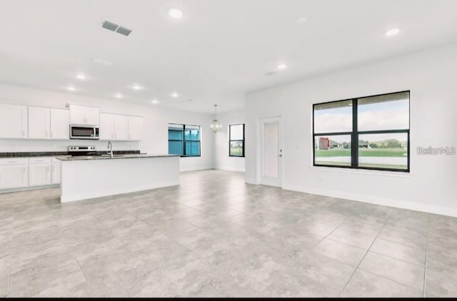 7002 162nd Pl E, Parrish, FL 34219 - kitchen with stainless steel microwave, dark countertops, open floor plan, visible vents, and recessed lighting